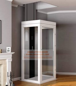 A modern residential glass elevator with a white frame and black paneling inside a room.