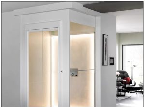 Interior view of a modern residential elevator with glass doors and soft lighting.