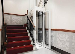 a white shaftless home lift with glass panel