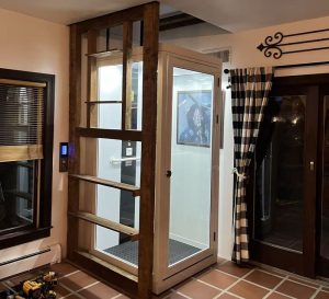 A white home elevator installed on the corner of a house