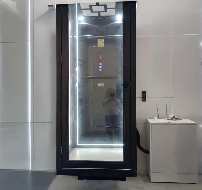 a black home elevator cabin with lights on the top ceiling